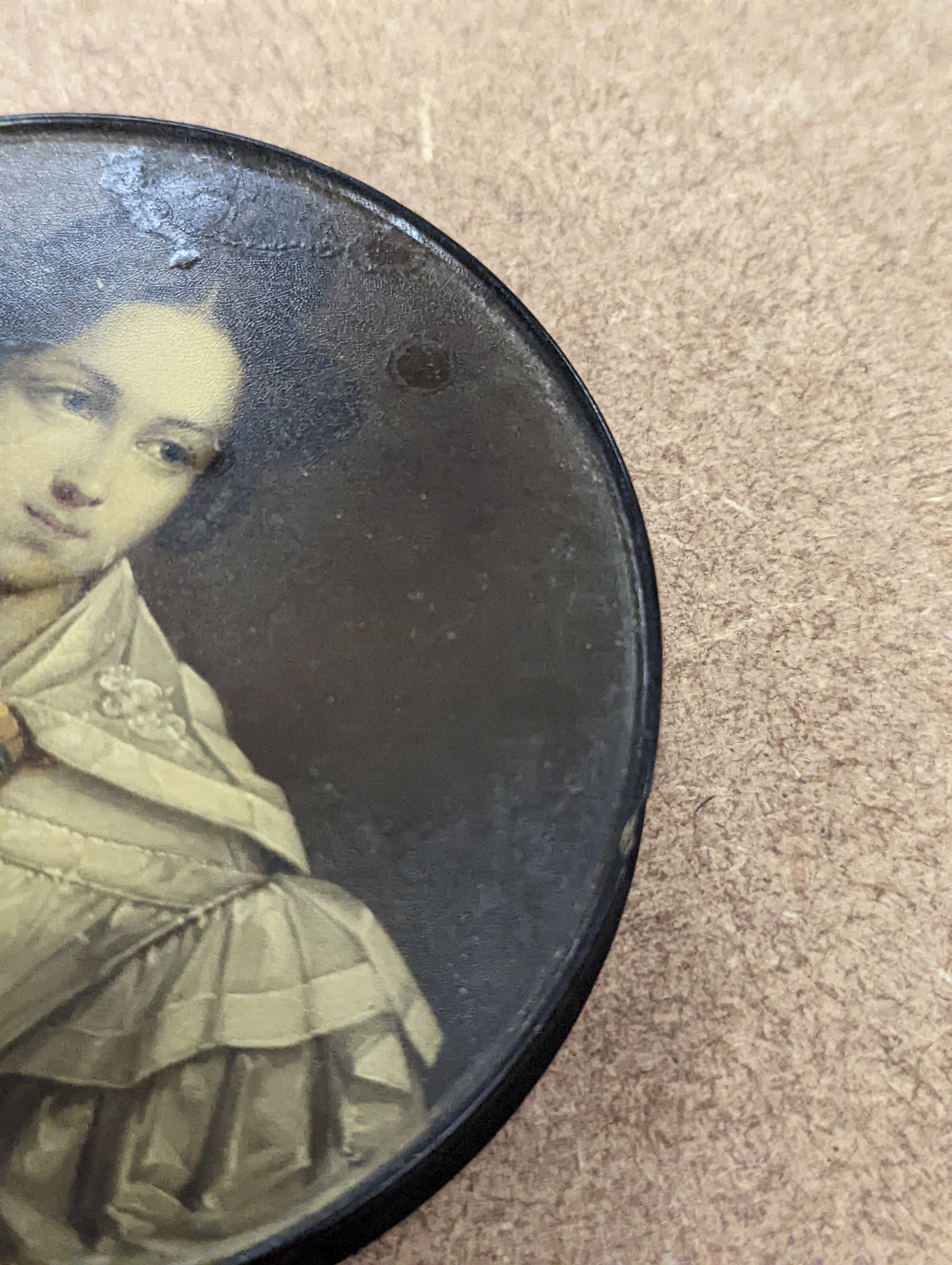 A 19th century Stobwasser papier mache ‘Henriette Sonntag’ portrait snuff box, c.1830, 9.7cm diameter and a 19th-century papier mache snuff box painted with a portrait of a German hussar, 9.4cm (2)